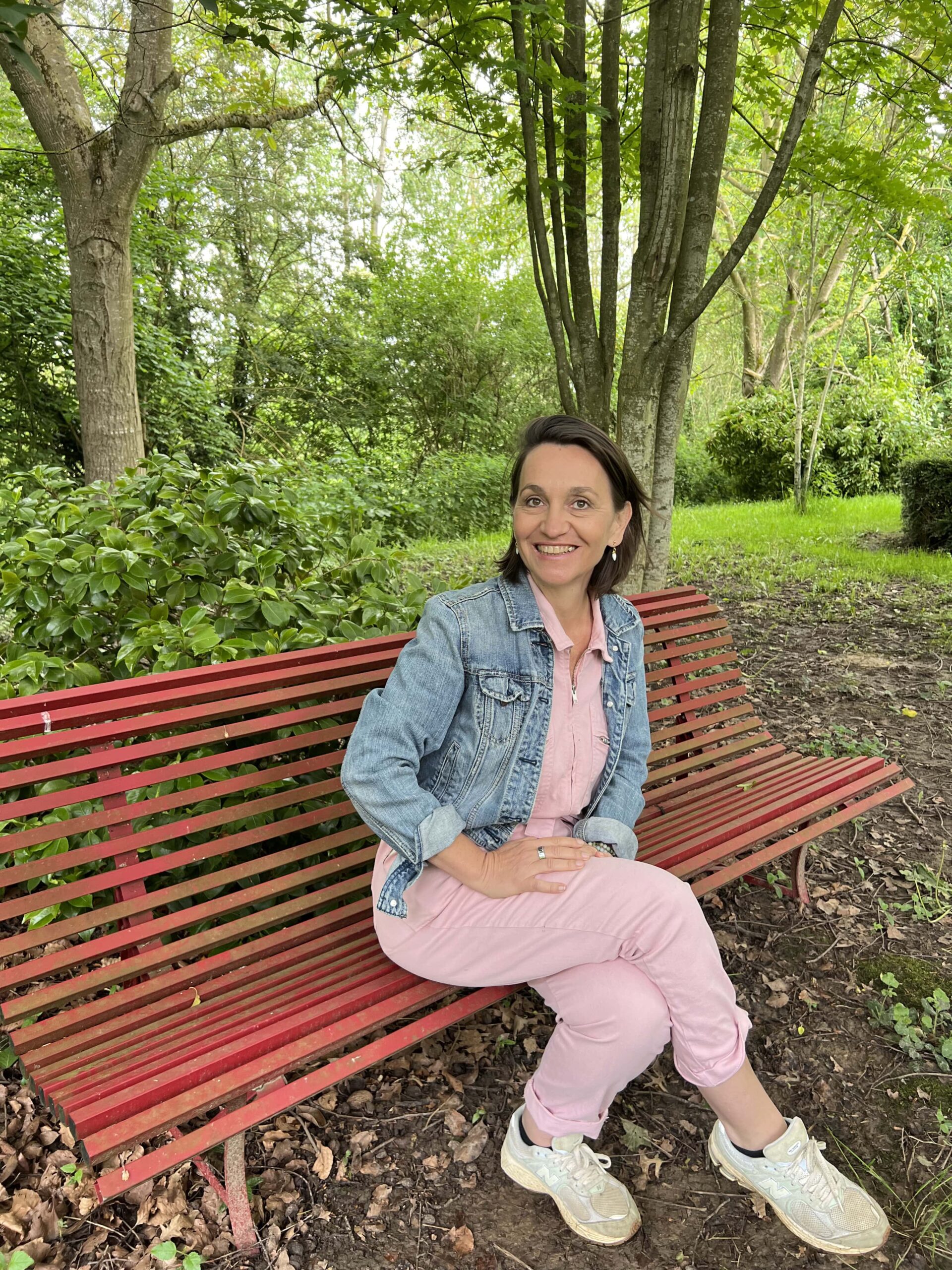 Anne Poignant assise sur un banc dans le parc